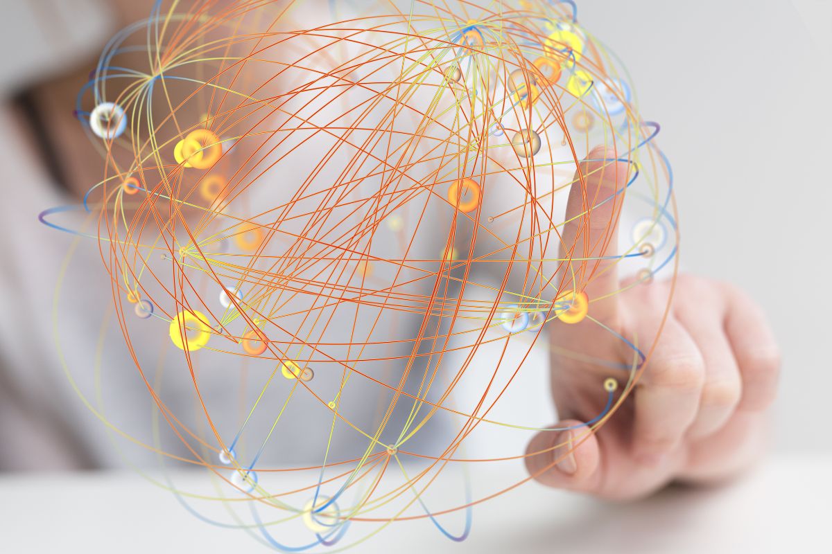 A graphic of what looks like atoms circling around a nucleus is traced by a woman's finger